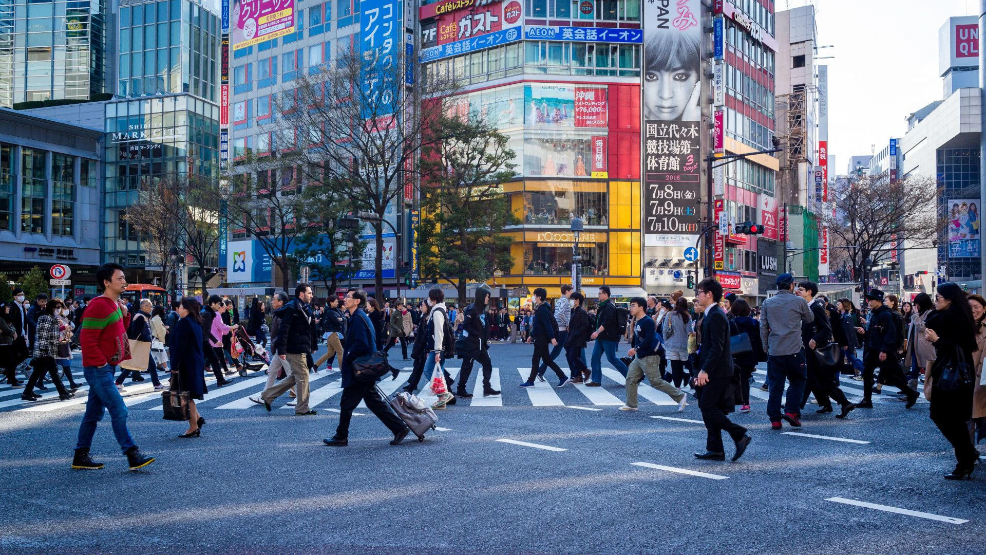 Persone che attraversano un incrocio a Tokyo alla fine della giornata.
